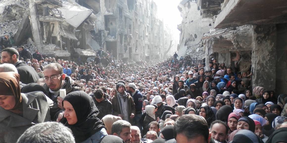 I det palestinska flyktinglägret Yarmouk i Damaskus har tillgången till mat varit väldigt begränsat under kriget. Befolkningen står i kö för att få mat från FN. (Januari 2014). Foto: Zuma Press/UNRWA